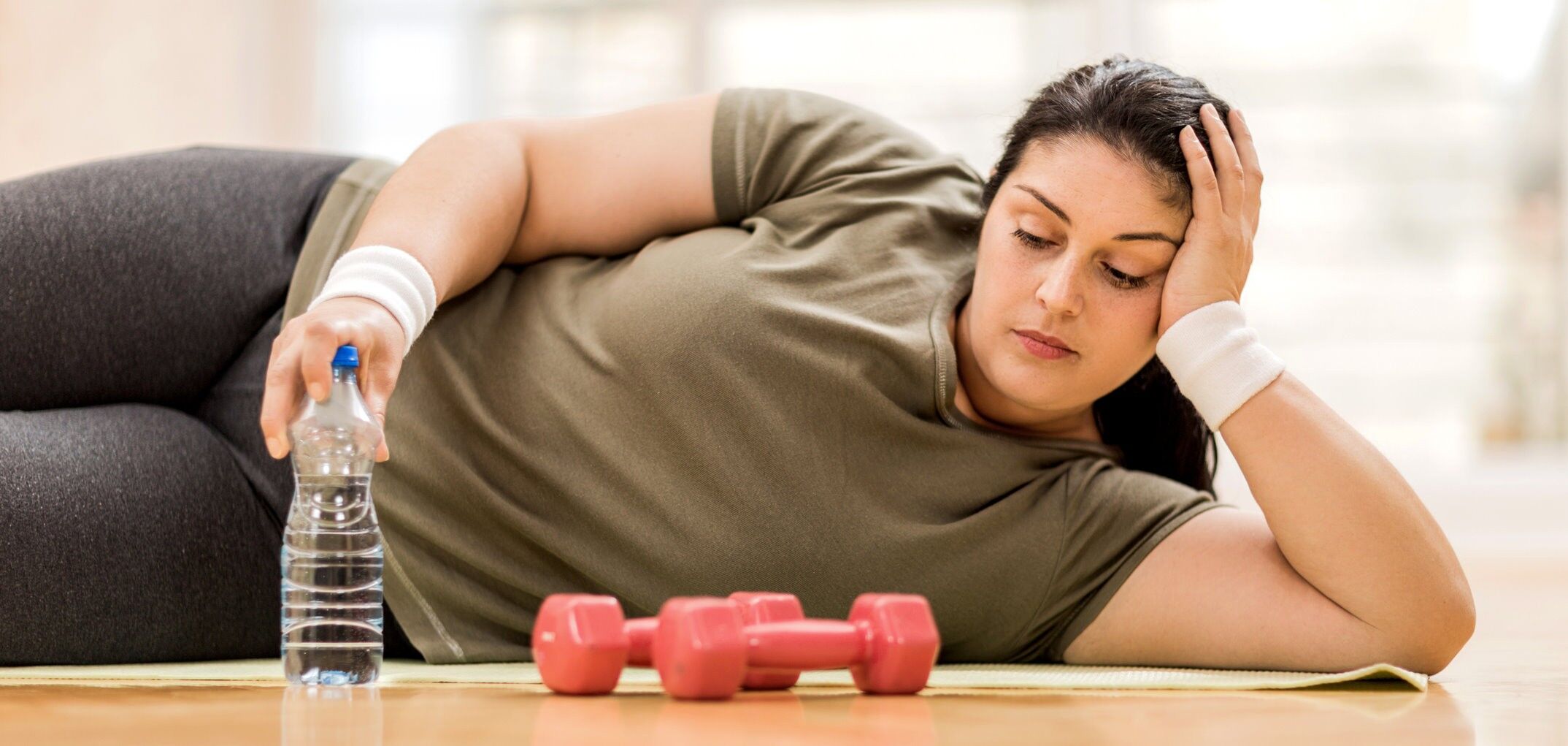 schlanke Frau in Hockestellung vor Mauer